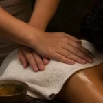 Mains d'une praticienne pendant un massage du dos